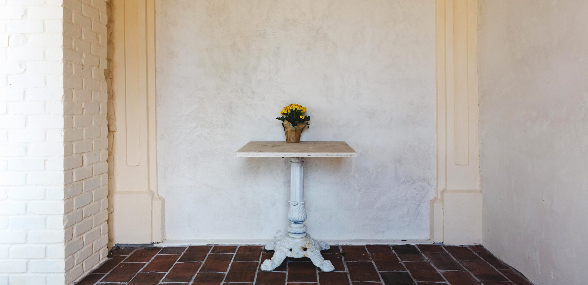 Flowers on a table in the portico between the kitchen and the pétanque court